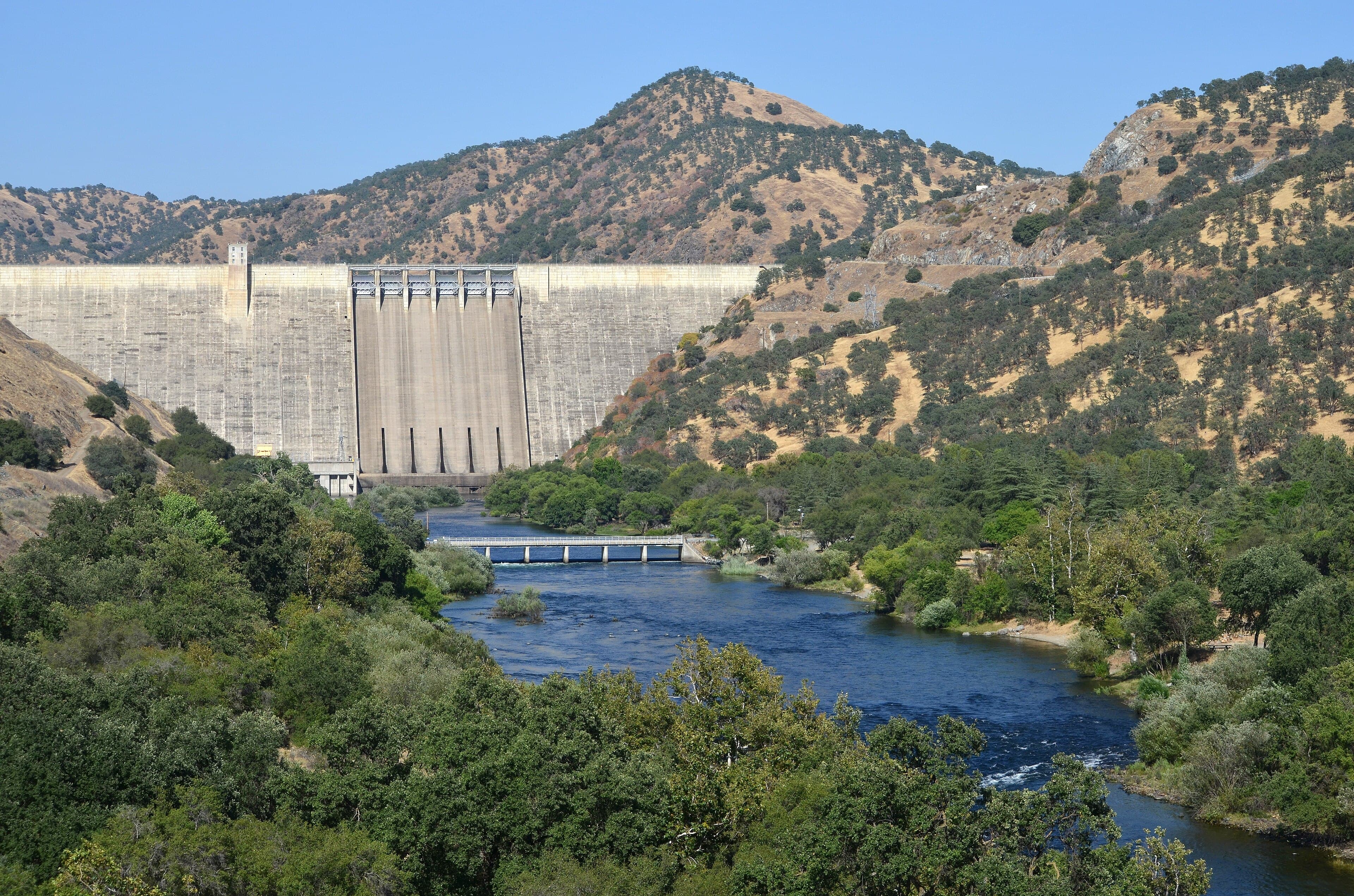 Hydropower dam and river flowing through a forested valley